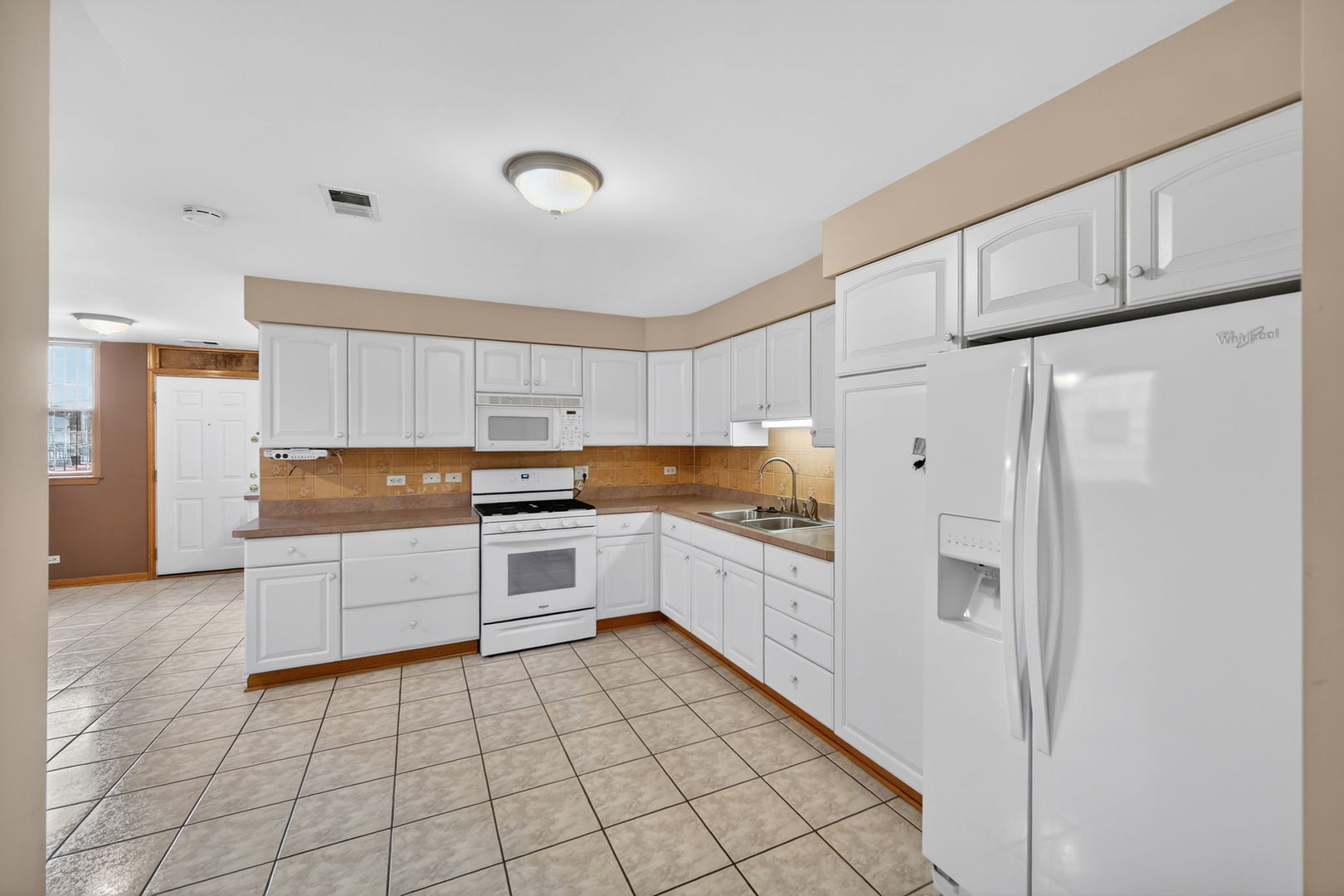 4369 North Elston Avenue Chicago, IL 60641 - Photo 24 of 43 a kitchen with granite countertop a refrigerator and white cabinets