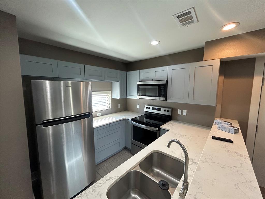 301 East Brockett Street Sherman, TX 75090 - Photo 4 of 14 a kitchen with stainless steel appliances granite countertop a refrigerator a stove top oven a sink and dishwasher