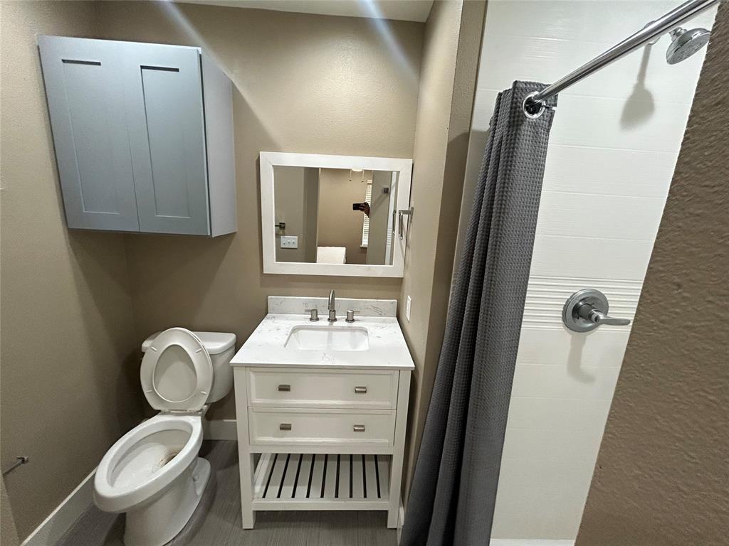 301 East Brockett Street Sherman, TX 75090 - Photo 10 of 14 a bathroom with a toilet sink and mirror