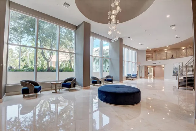 a living room with furniture and floor to ceiling windows