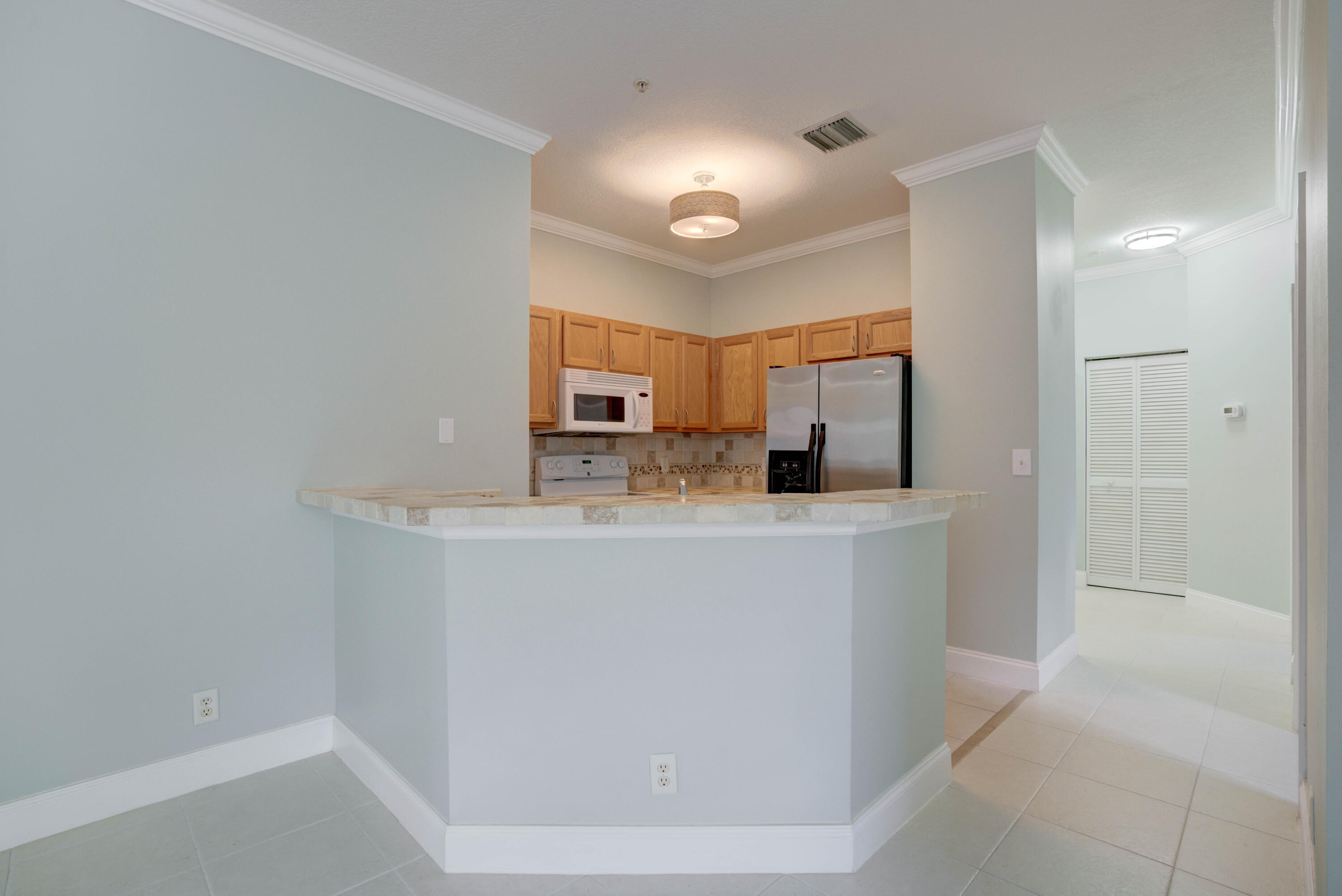 115 Lighthouse Circle, Unit B Tequesta, FL 33469 - Photo 24 of 42 a view of cabinets and wooden floor