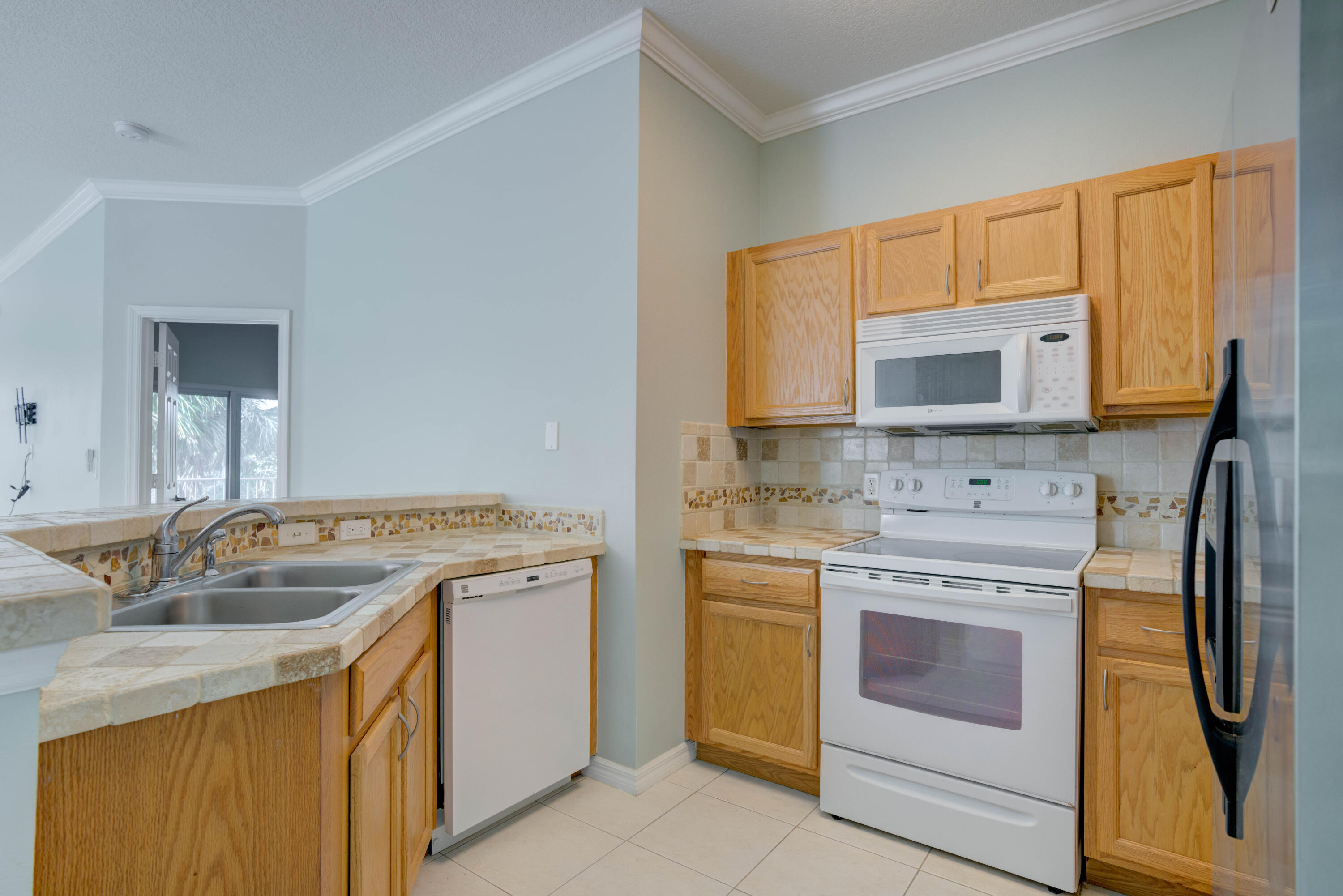 115 Lighthouse Circle, Unit B Tequesta, FL 33469 - Photo 26 of 42 a kitchen with stainless steel appliances granite countertop a stove microwave and cabinets