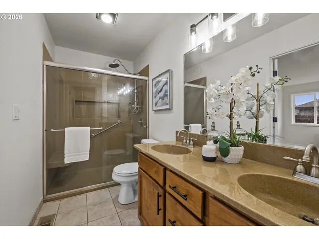 a bathroom with a shower sink vanity mirror and toilet