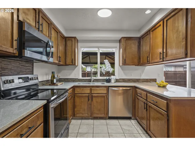 a kitchen with stainless steel appliances granite countertop a sink stove and cabinets