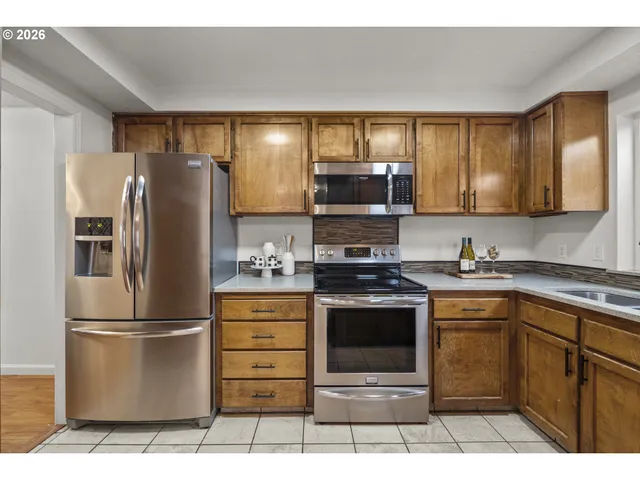 a kitchen with stainless steel appliances granite countertop a refrigerator stove and sink