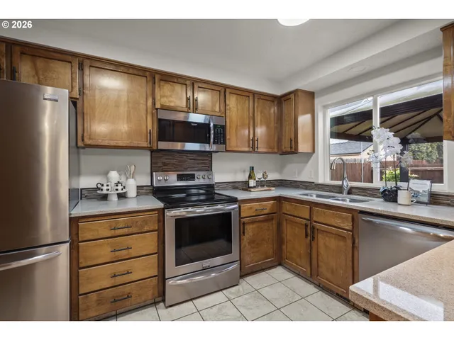 a kitchen with stainless steel appliances granite countertop a stove a sink and a refrigerator