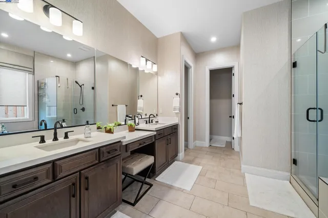 a spacious bathroom with a double vanity sink mirror and shower