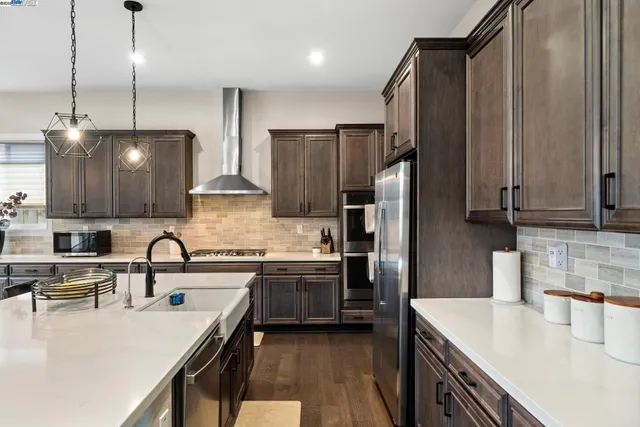 a kitchen with stainless steel appliances granite countertop a sink refrigerator and cabinets