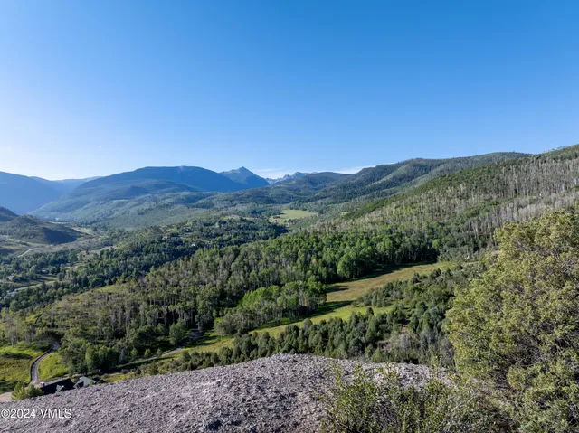 a view of a mountain range with lush green forest