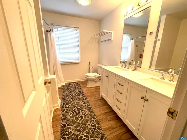 a bathroom with a double vanity sink and mirror with shower