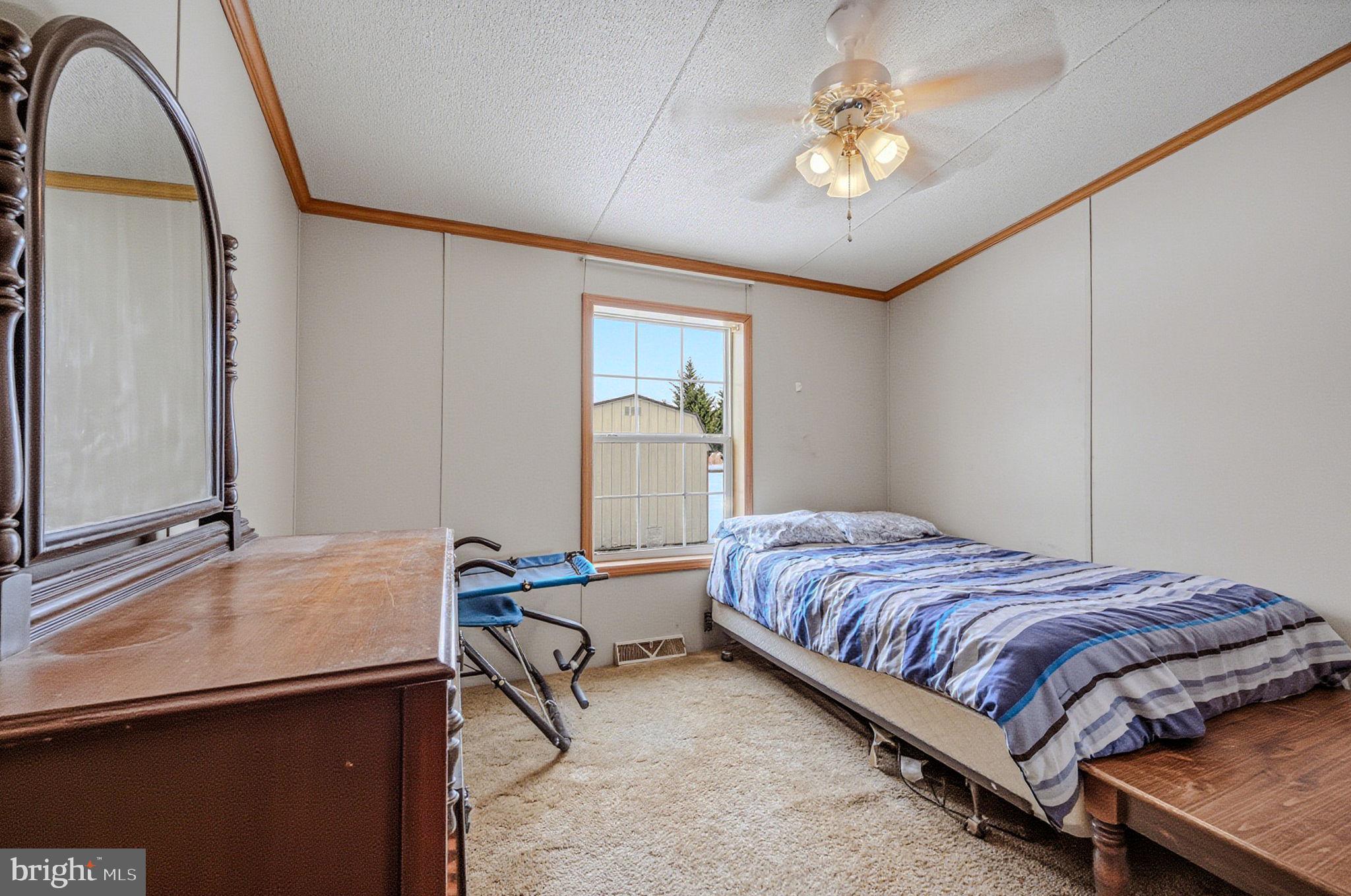 2237 Marshyhope Road Felton, DE 19943 - Photo 35 of 38 a bedroom with a bed and a chandelier