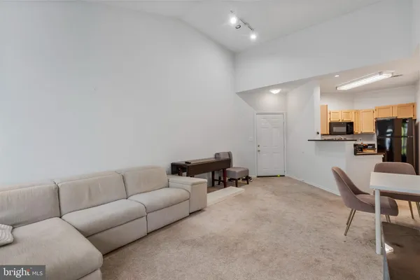 a living room with furniture and a dining table with kitchen view