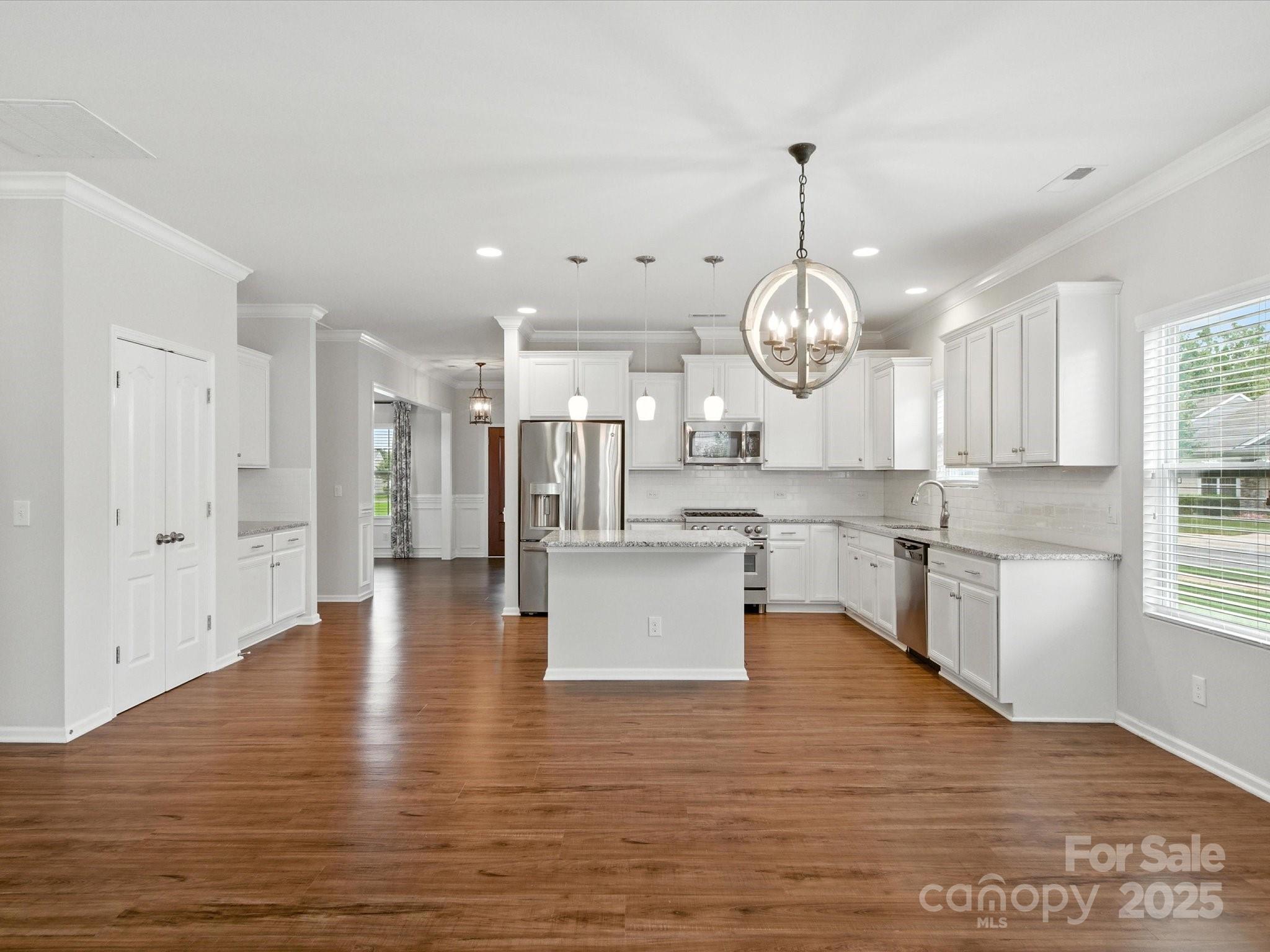 1628 Spring Blossom Trail Fort Mill, SC 29708 - Photo 16 of 42 a large kitchen with stainless steel appliances granite countertop a large kitchen island a refrigerator a stove a sink and a wooden floors
