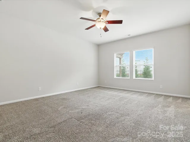an empty room with fan and windows