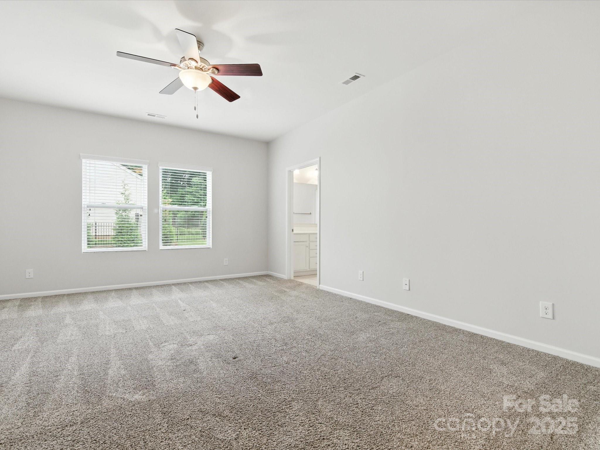 1628 Spring Blossom Trail Fort Mill, SC 29708 - Photo 23 of 42 an empty room with windows and fan
