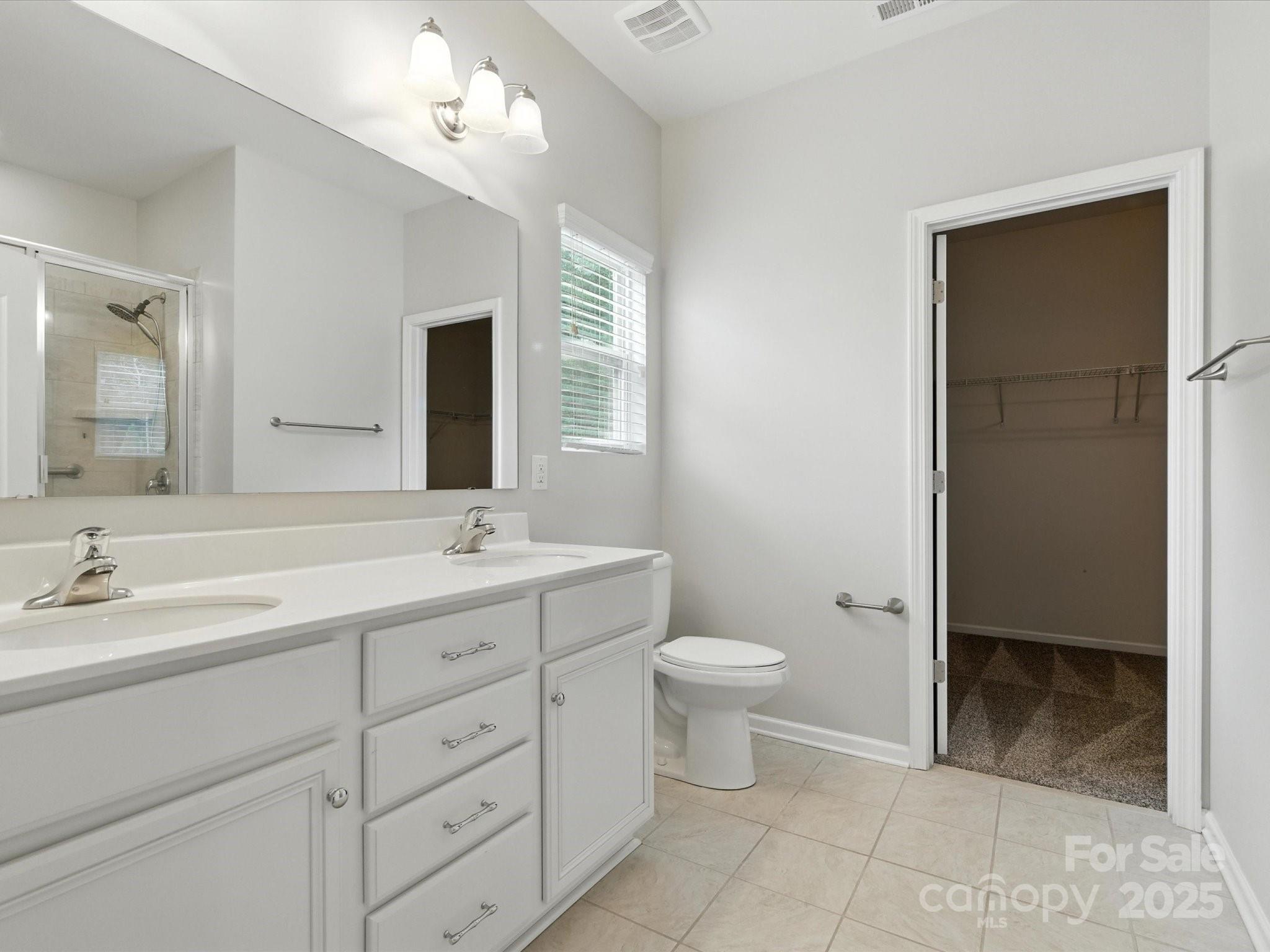 1628 Spring Blossom Trail Fort Mill, SC 29708 - Photo 25 of 42 a bathroom with a double vanity sink a toilet and a mirror