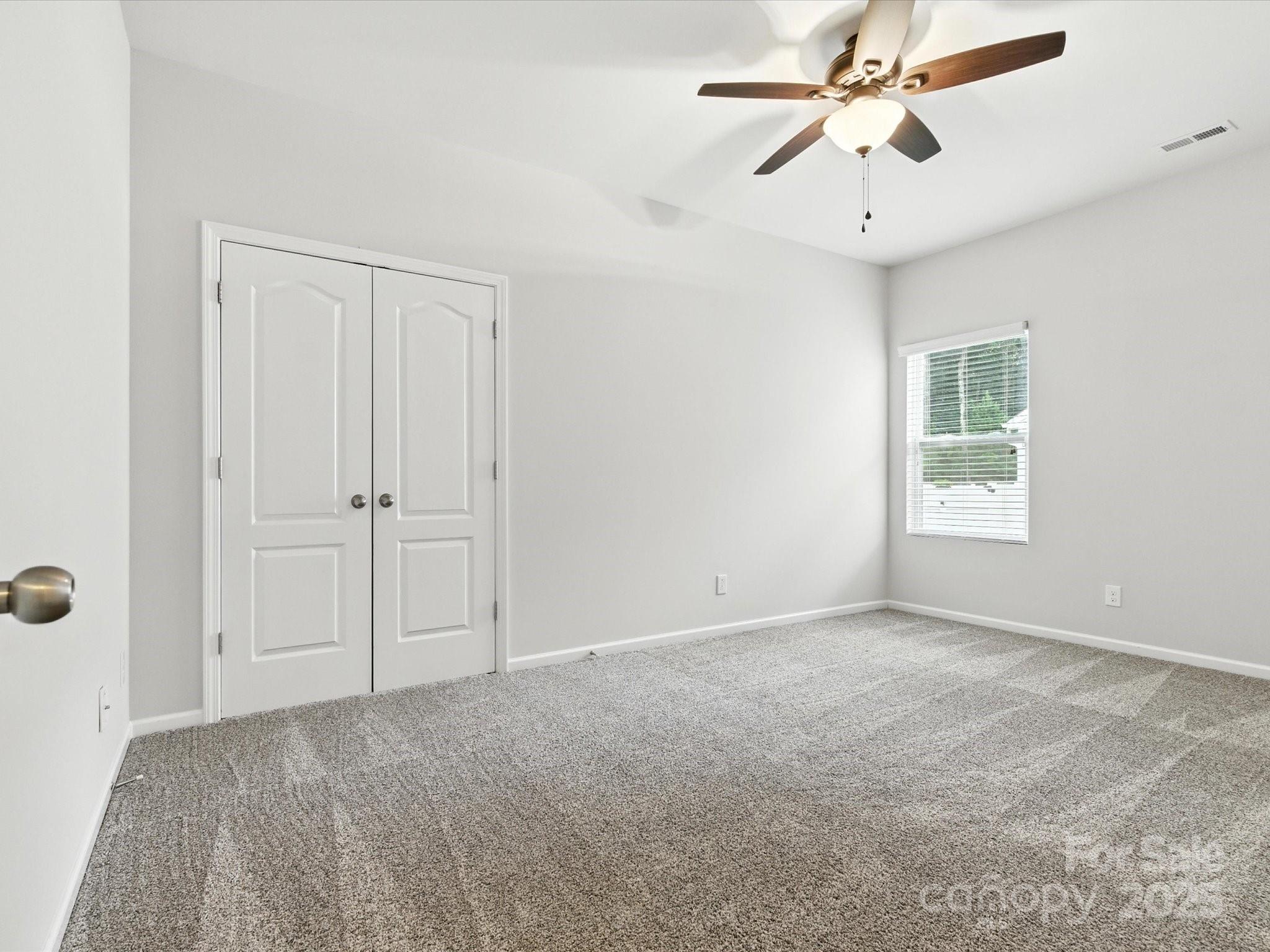 1628 Spring Blossom Trail Fort Mill, SC 29708 - Photo 28 of 42 an empty room with windows and fan