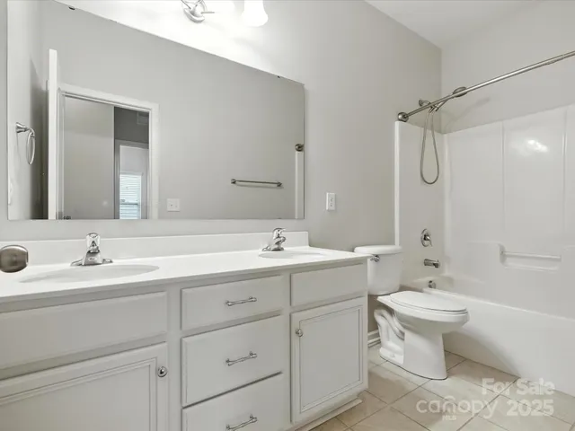 a bathroom with a double vanity sink mirror and toilet