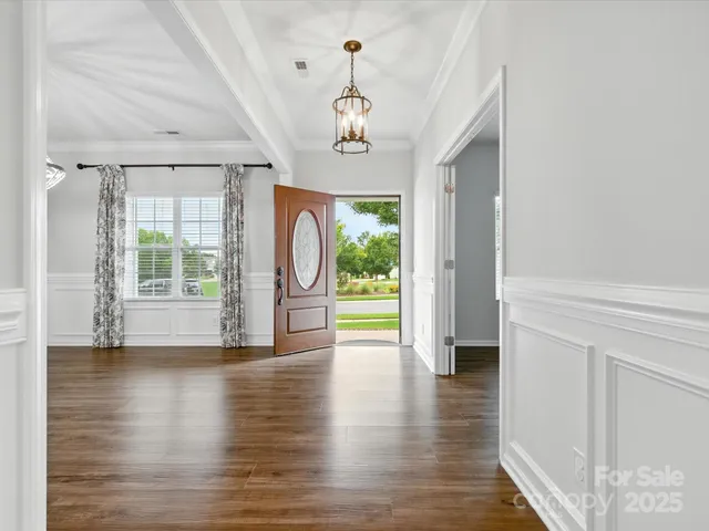 a view of a room with wooden floor fireplace and windows