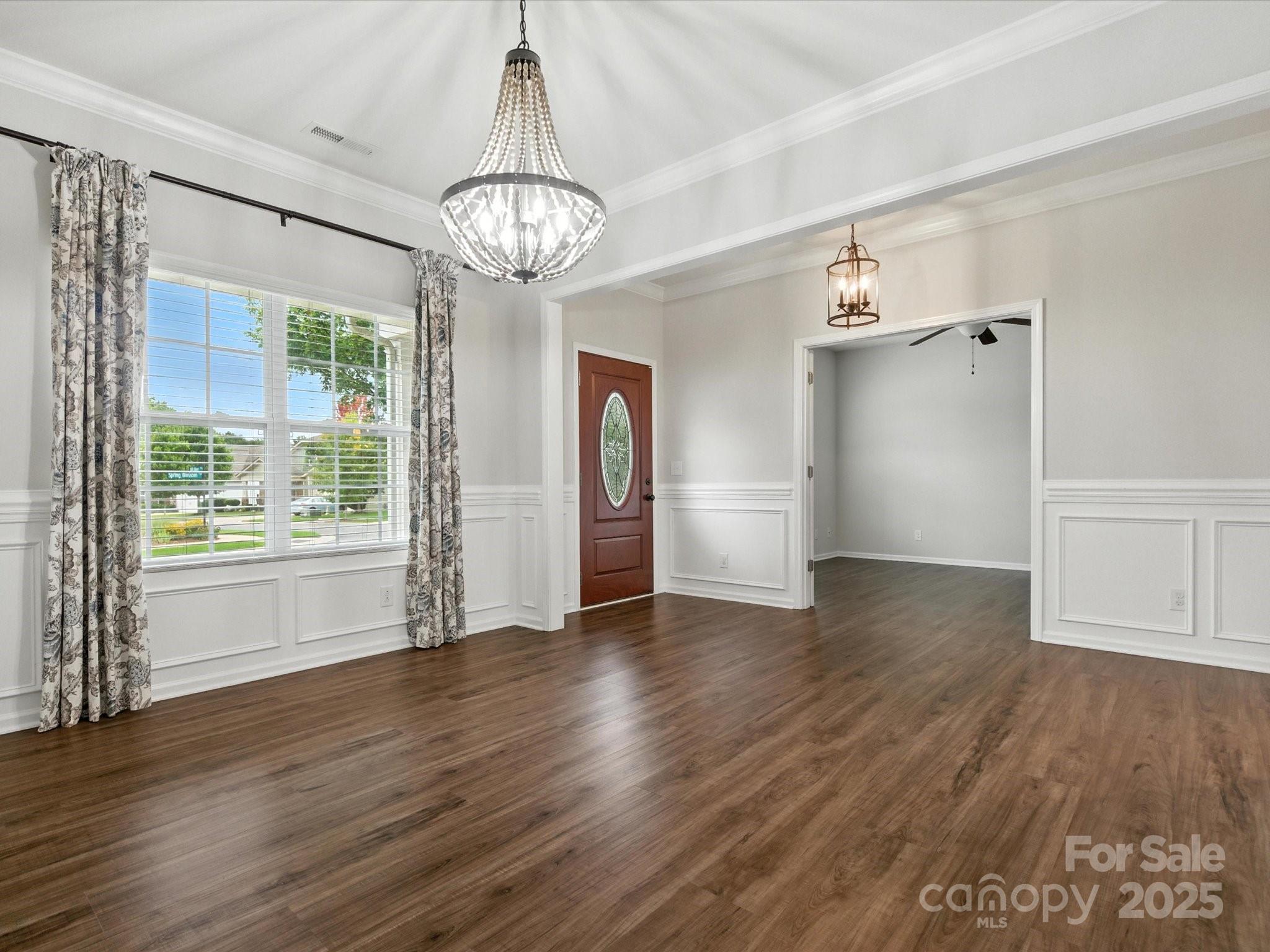 1628 Spring Blossom Trail Fort Mill, SC 29708 - Photo 5 of 42 an empty room with wooden floor chandelier and windows