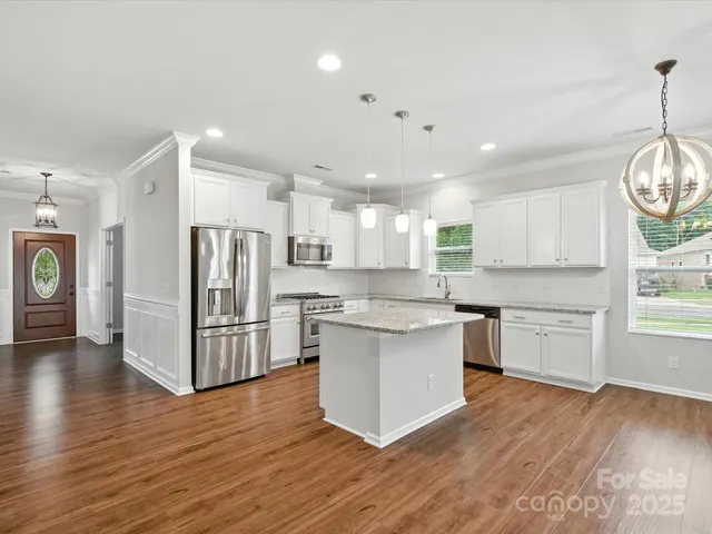 a kitchen with stainless steel appliances granite countertop a white stove top oven and refrigerator