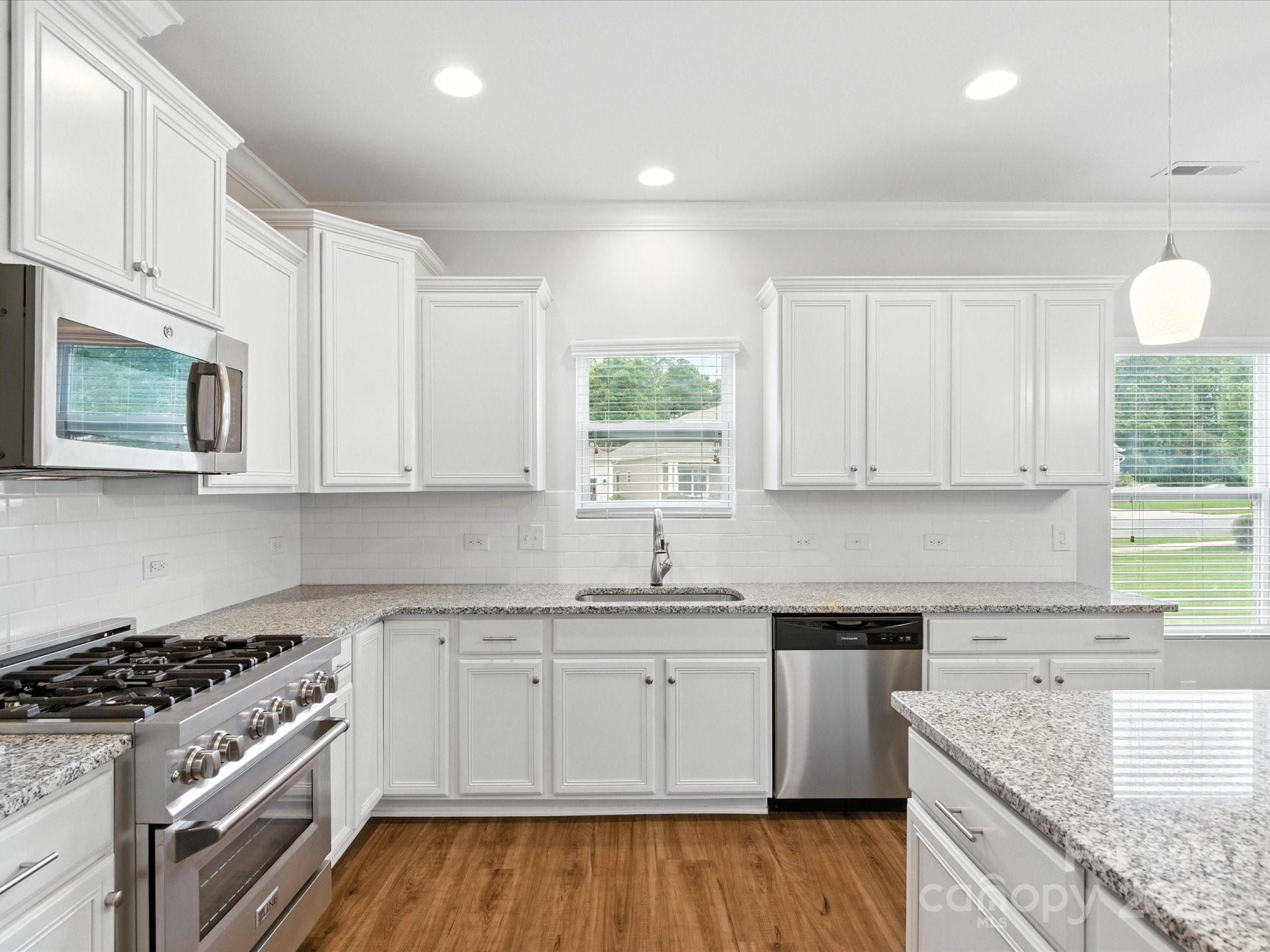 1628 Spring Blossom Trail Fort Mill, SC 29708 - Photo 10 of 42 a kitchen with granite countertop cabinets stainless steel appliances and a wooden floor