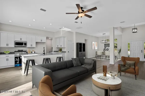 an empty room with wooden floor and ceiling fan