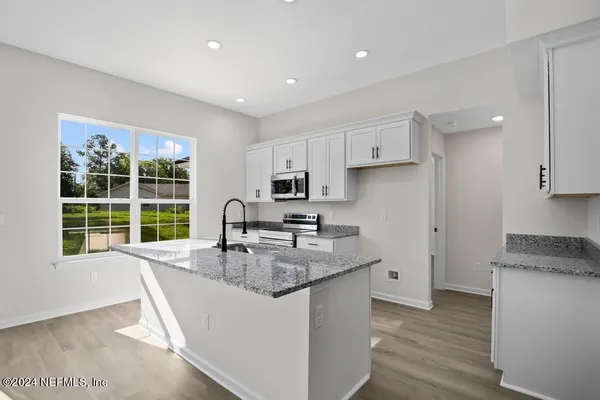 a kitchen with granite countertop a sink and a window