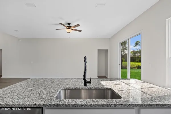 a kitchen with granite countertop a sink white cabinets and a granite counter tops