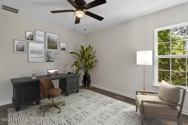 an empty room with wooden floor and ceiling fan