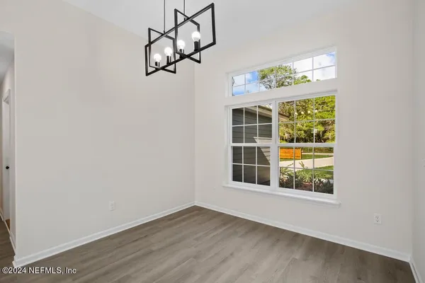 a view of a room with wooden floor and large windows