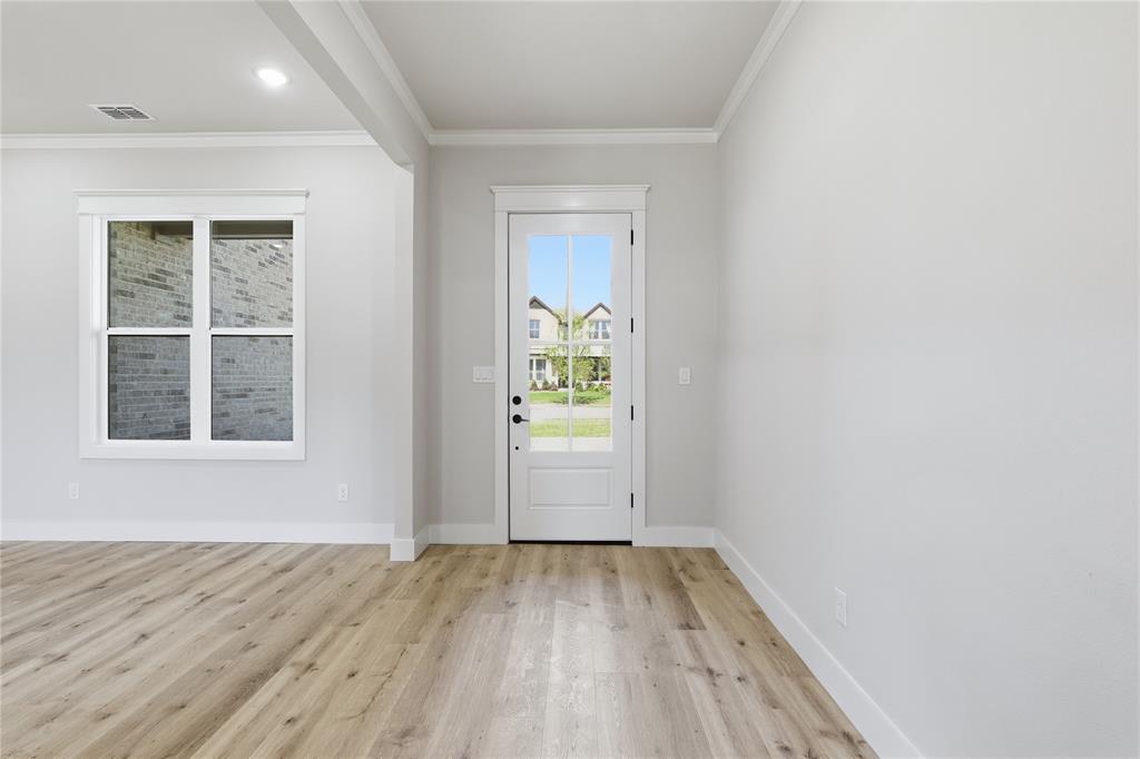 713 Anne Road Van Alstyne, TX 75495 - Photo 3 of 29 Light wood-finish flooring extending throughout, complemented by crisp white baseboards and crown molding