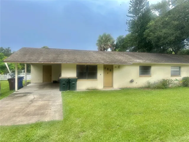 a front view of a house with a garden and yard