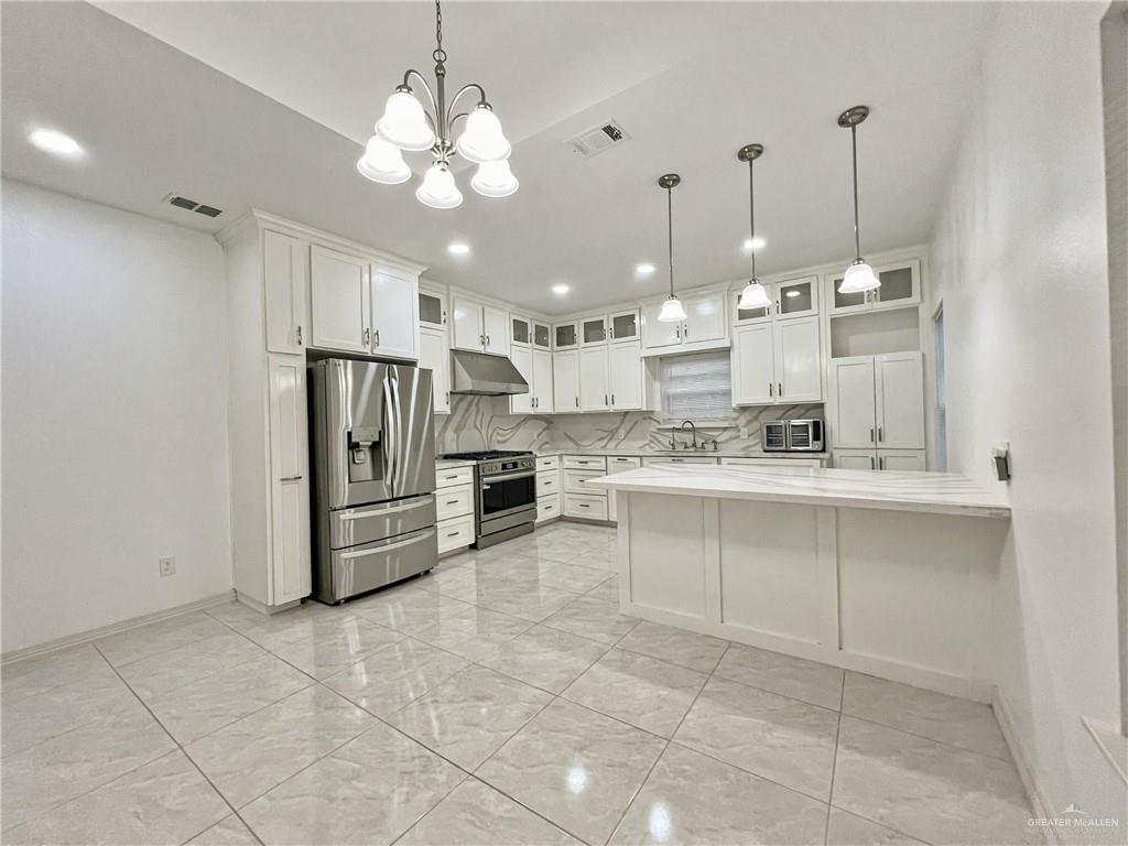 7723 Villa Rama S Street Mission, TX 78572 - Photo 4 of 15 a kitchen with kitchen island granite countertop cabinets and refrigerator
