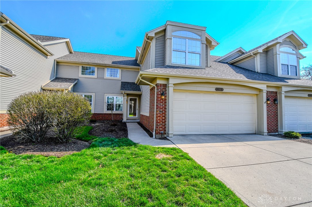 This charming residence features an attached garage and a well-maintained lawn.