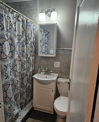 a bathroom with a toilet sink and mirror