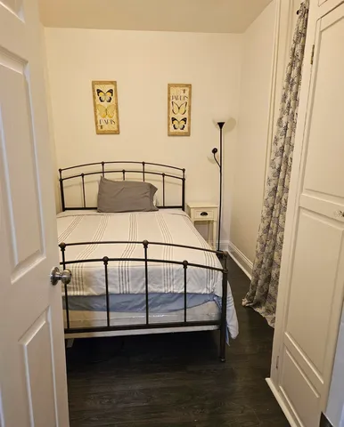 a bedroom with a bed next to a window