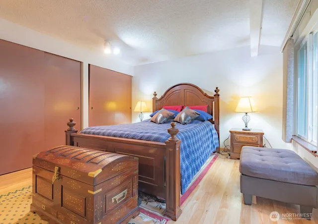 a bedroom with a bed and wooden floor