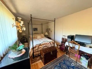 a bed sitting in a bedroom next to a window