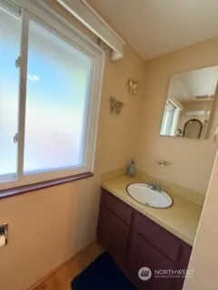 a bathroom with a sink a mirror and a window