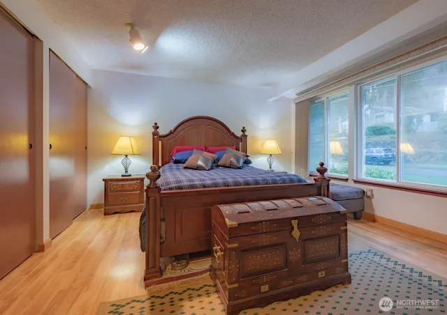 a bedroom with a bed and large windows