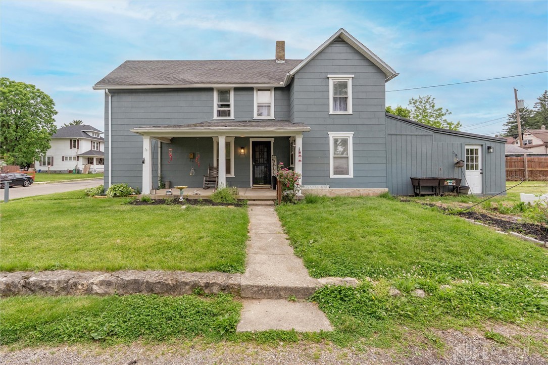 1726 Morgan Street Springfield, OH 45503 - Photo 2 of 30 This classic residence features a welcoming porch and a lush green lawn, offering a serene outdoor space.