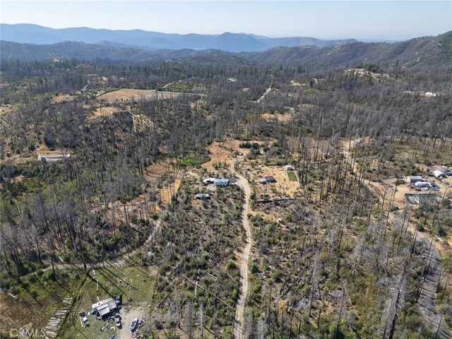 an aerial view of a house with a yard swimming pool and sitting area
