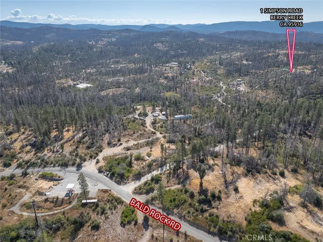 an aerial view of a house with a yard and lake view