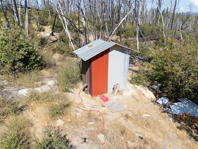 a view of a backyard with plants and trees with wooden fence