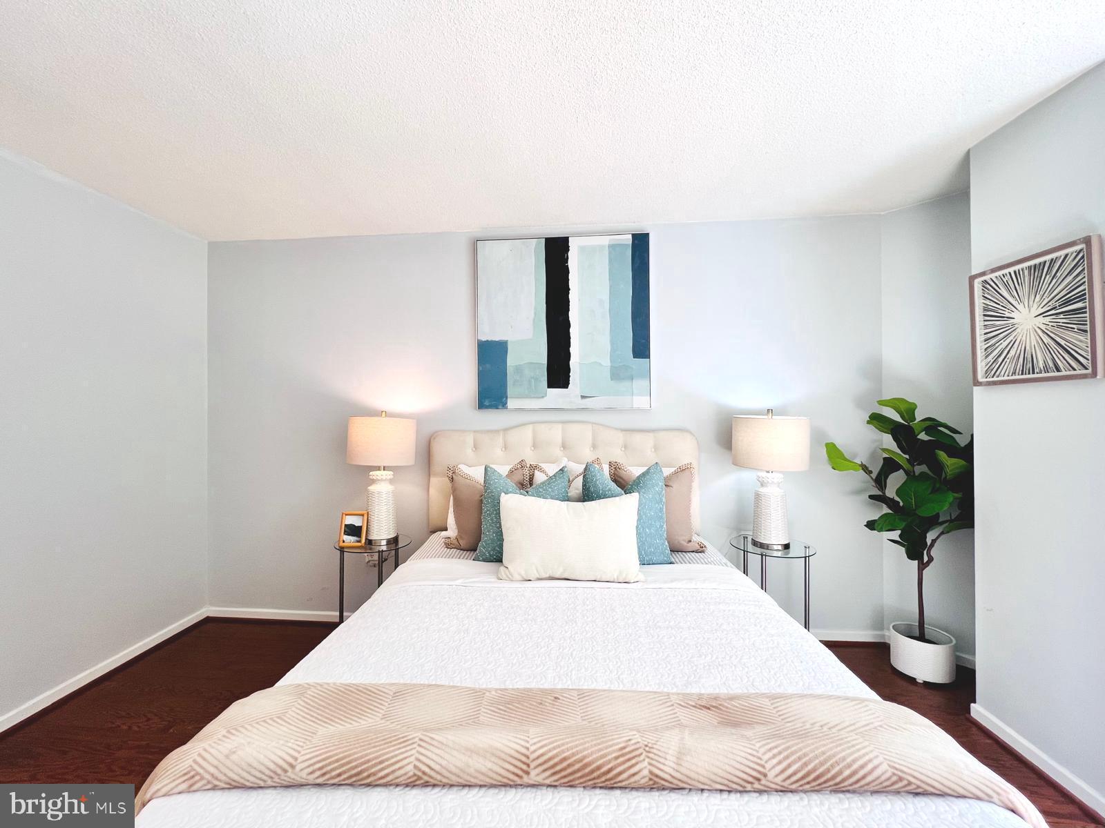2111 Wisconsin Avenue Northwest, Unit 110 Washington, DC 20007 - Photo 12 of 32 a bedroom with a large bed and a potted plant