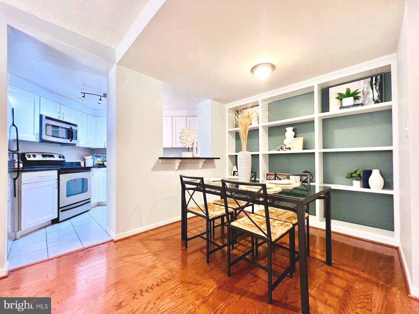 2111 Wisconsin Avenue Northwest, Unit 110 Washington, DC 20007 - Photo 5 of 32 a kitchen with stainless steel appliances kitchen island granite countertop a table chairs sink and cabinets