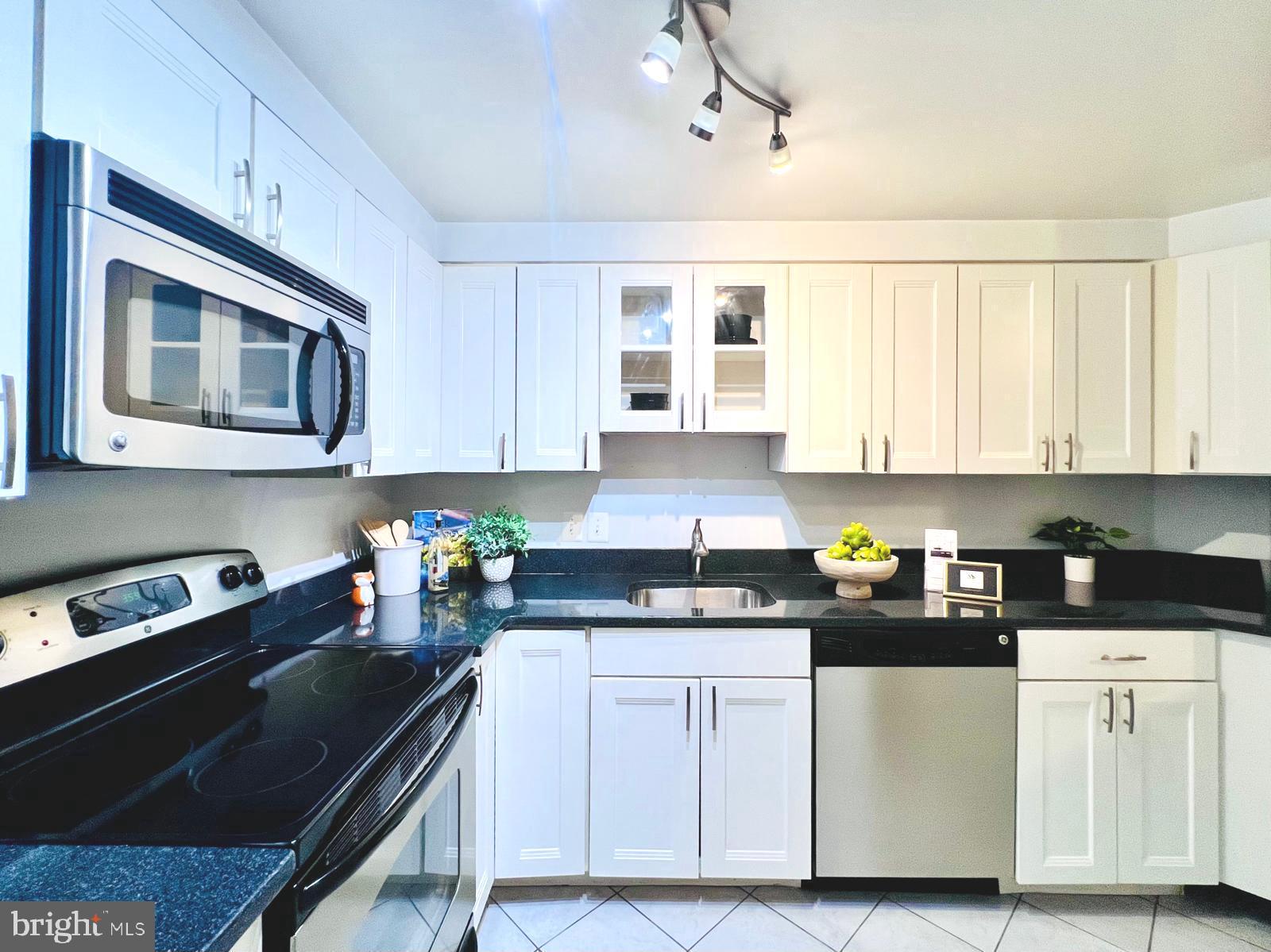 2111 Wisconsin Avenue Northwest, Unit 110 Washington, DC 20007 - Photo 8 of 32 a kitchen with stainless steel appliances granite countertop a stove a sink and white cabinets