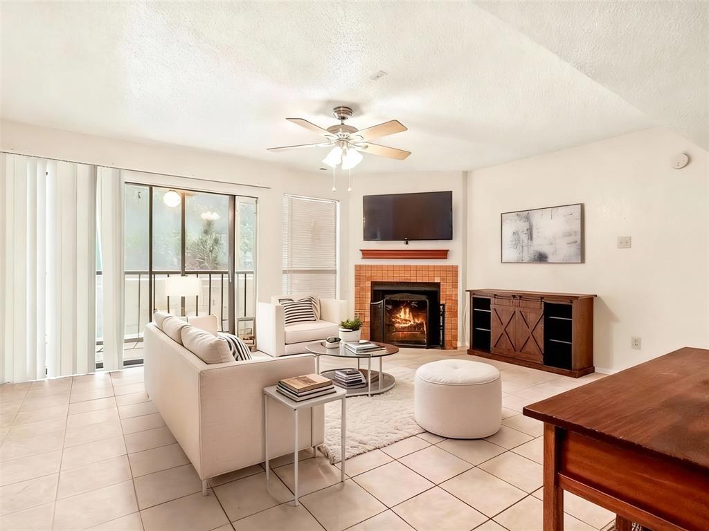 11460 Audelia Road, Unit 172 Dallas, TX 75243 - Photo 13 of 38 a living room with furniture a fireplace and a flat screen tv