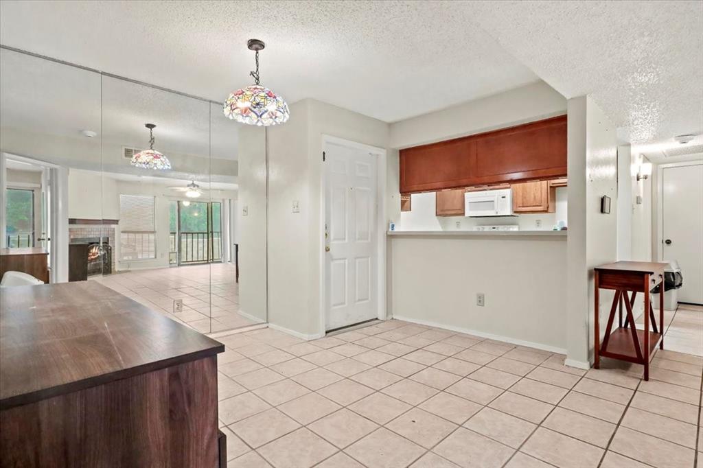 11460 Audelia Road, Unit 172 Dallas, TX 75243 - Photo 17 of 38 a living room with kitchen island granite countertop furniture and a chandelier